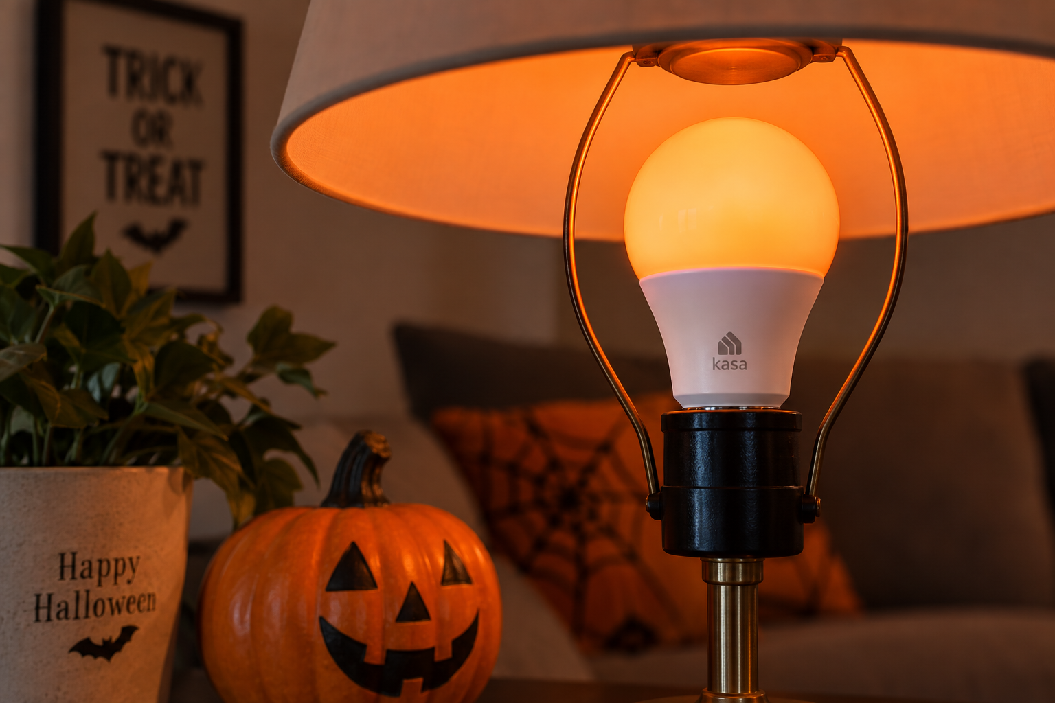 Kasa KL125-style smart bulb glowing orange in a table lamp for reusable Halloween lighting